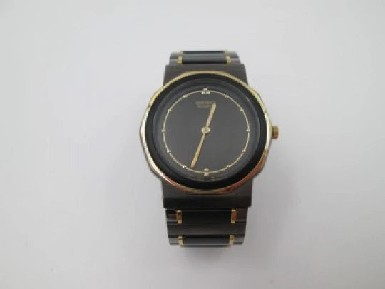 Seiko. Black and gold metal. Steel back. Quartz. Round case. Bracelet. 1980's. Japan